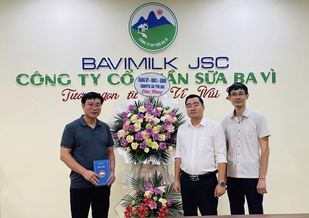 Ông Chu Văn Hiếu - Phó giám đốc phụ trách Sản Xuất đón nhận lẵng hoa từ ông Nguyễn Thành Sơn - Phó chủ tịch UBND xã Yên Bài